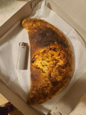 Horrible calzone which is tiny, see the lighter!