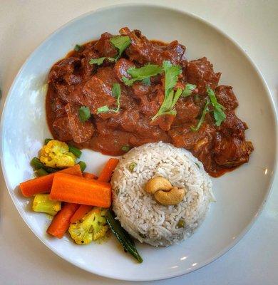 Spicy Goat (bone in) cooked with fresh Indian spices (mild, medium and hot options) with steamed vegetable and rice.