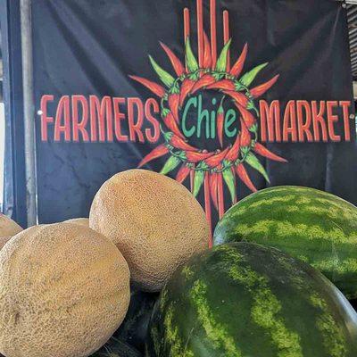 cantaloupes and watermelons in Front of Farmers Chile Market sign