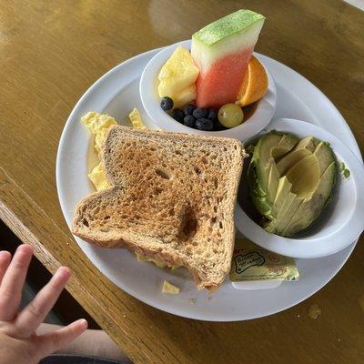 Two scrambled eggs, wheat toast, avocado and beautiful fruit cup!