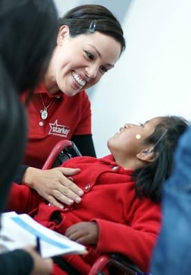 Dr. Kim Ortega on a mission trip to Peru fitting this precious child with aids.