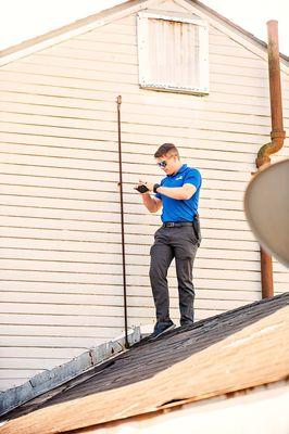 Inspector capturing deficiencies of roofing material