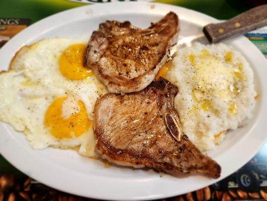 Pork chops, eggs, sunny side up and grits with added cheese