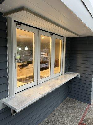 Custom pass through kitchen/bar window. Blending the inside and outside of a waterfront home.