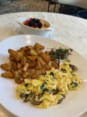 Scrambled eggs with veggies and potatoes and a side of fruit