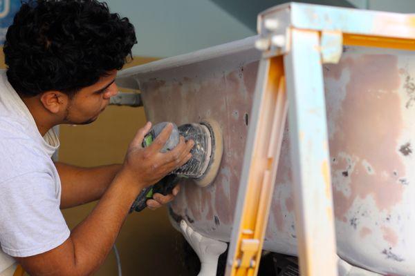 One of our skilled technicians sanding the outside of a clawfoot tub in preparation for its resurface.