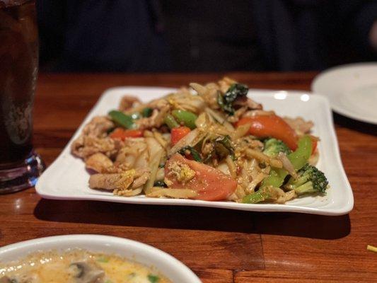 Wide rice noodles, veggies and chicken.