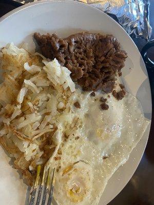 Huevo Ranchero plate with hash browns. Refried beans dry, over medium eggs over cooked!