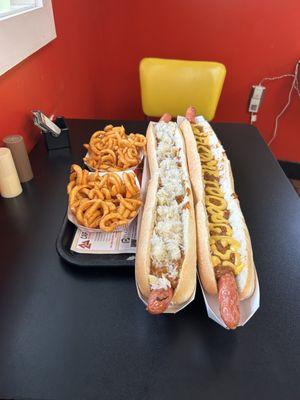 Curly fries, chili and cheese hot dogs. One with kraut, one without.