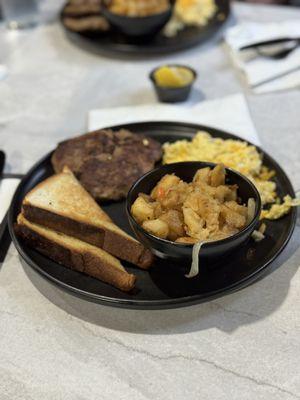 Potatoes, toast, scrambled eggs, and turkey sausage