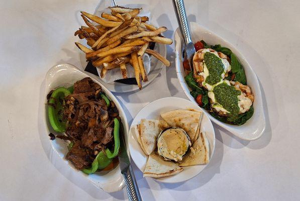 On the left is a stuffed green pepper and on the right is the pesto chicken (mine).  Rounding out these are fries and pita with hummus.