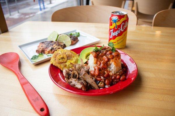 Pernil (roasted pork), tostones (fried plantains), rice, and beans. Everything is DELICIOUS