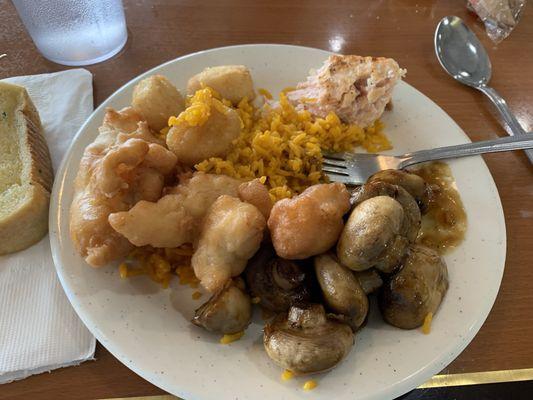 Buffet plate, sautéed mushrooms, fried rice, sweet and sour chicken, salmon, fish bites, and garlic bread. Love the mushrooms