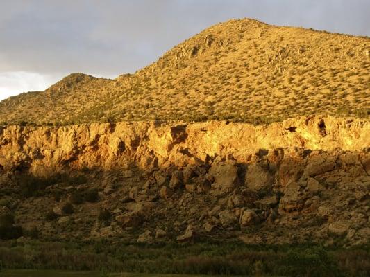 The La Madera range is Cliff River Springs' defining landmark. The Rio Ojo Caliente runs along the base of the cliffs.