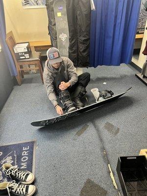 Our son trying on his boots after the bindings were mounted to the board.