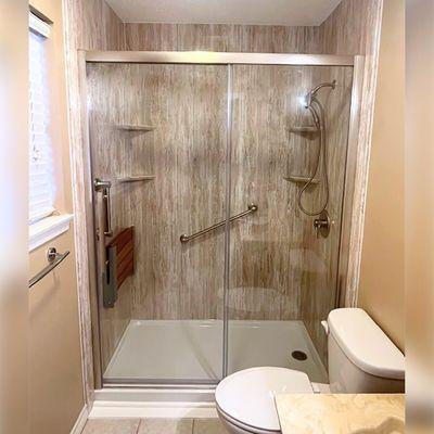 Beautiful walk-in shower with grab bars and in-shower bench.