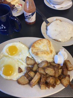 Chicken fried steak with gravy, eggs sunny side up potatoes and a biscuit