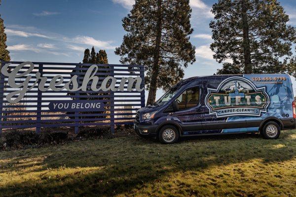 The Tufts Carpet Cleaning van is parked next to the "You Belong" sign in Gresham, OR, proudly serving