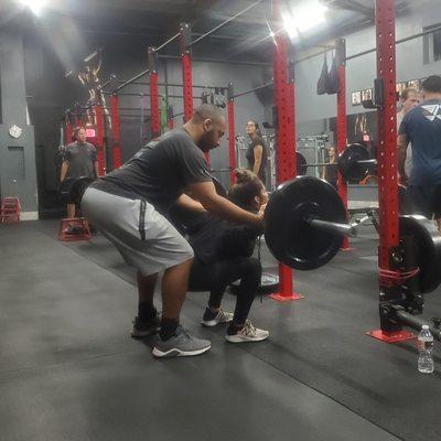 Here I am spotting my client in her squat to make sure she can push the weight up from the bottom of the lift.