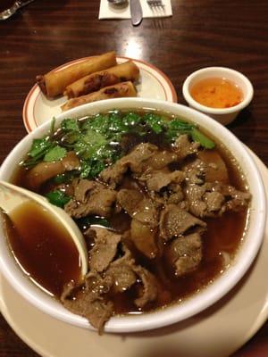 Pho Noodle Soup with Beef and Cilantro, Imperial Rolls in the background.