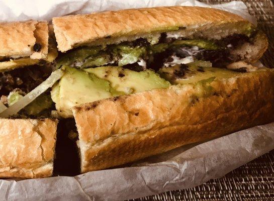 Breaded beef with black beans crema avocado & red onions on French bread