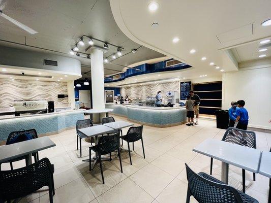 Clean white modern decor with cool blue glass tiles wrapped around the counters