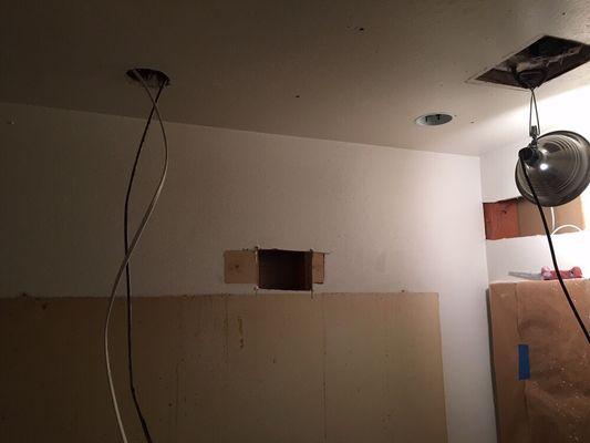 Electrical can lights being installed with new switches and circuits.