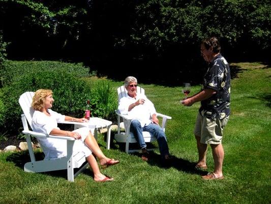 Innkeeper serves wine to guests in the garden.