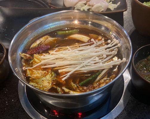 Spicy Szechuan hot pot with Napa cabbage and enoki mushrooms and ramen noodles