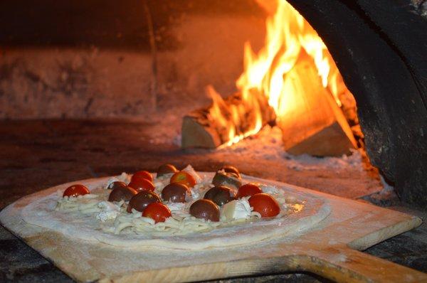 A Black Cherry Tomato Pizza Special going into the oven.