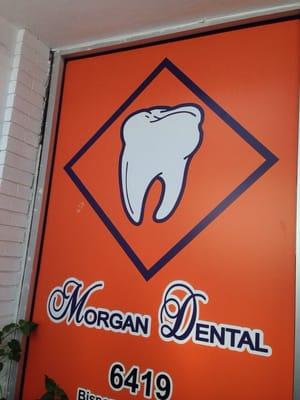 Barely visible from the parking lot, the Morgan Dental sign is next to the door that leads to the dental office.