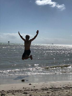 My husband leaping for joy to be swimming in November