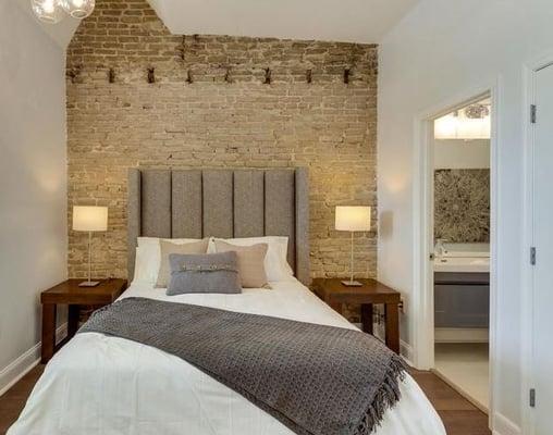 Staged master bedroom with tall upholstered headboard and classic white bedding.  Location Washington, DC