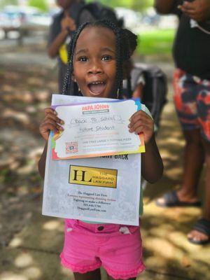 A young student at our back-to-school event in August 2023 at Perrine Park. She was so excited to receive her free pizza certificate!