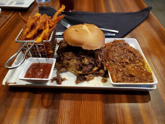 Brisket sandwich with sweet potato fries and baked beans.