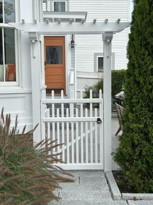 Pergola arbor in white with custom gate and premium Snug Cottage hardware.