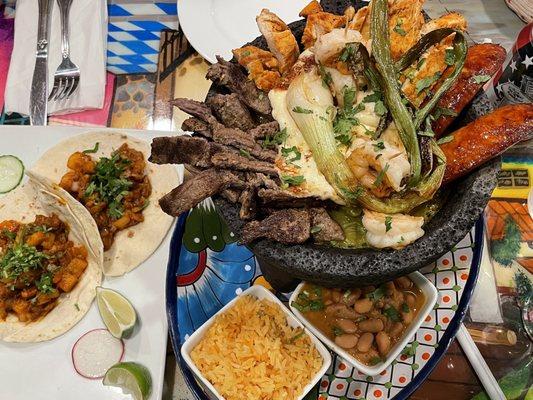 Tacos Al pastor on the left and molcajete on the right