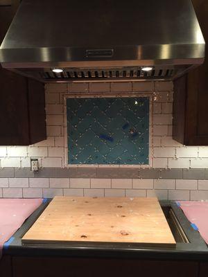 Custom mosaic tile backsplash with a pot filler