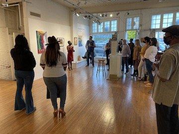 Gallery attendees receiving artist's talk about Gay Pasley's work.