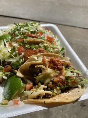 Carne asada tacos with their red salsa sauce