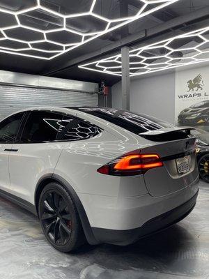 Tesla model X wrapped in gloss "chalk" with full chrome delete and calipers painted gloss red