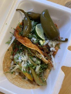 Grilled veggie taco and mushroom taco with a side of pickled jalapeños