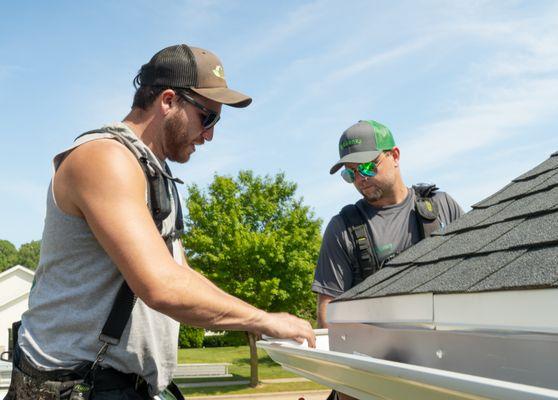 Larson & Keeney Contractors Installing a New Gutter System on a House