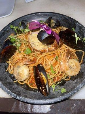 Lobster tail, mussels, shrimp over a tomato pasta base.