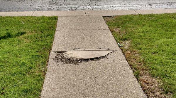 Entrance walkway deteriorated and a trip hazard. This is what you have to maneuver to enter our building