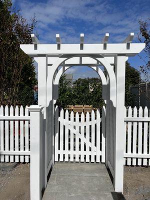 Full double pergola style arbor with a scalloped cape cod picket gate.