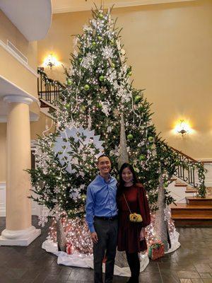 Inside the clubhouse in front of the large Christmas tree.