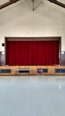 The stage curtains (closed) in the auditorium