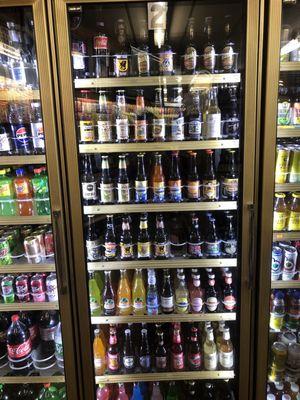 Refrigerated case with so many different root beers and other non alcoholic drinks.