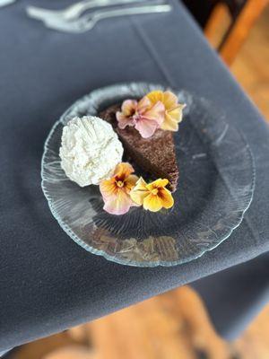 Flourless chocolate cake with vanilla bean ice cream and edible flowers